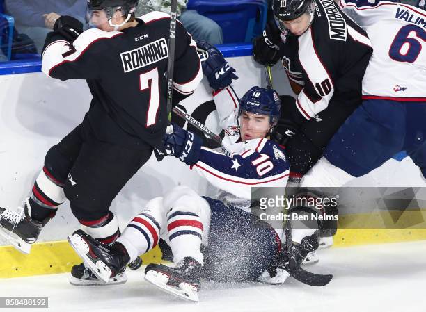 Dylan Coughlan of the Tri-City Americans is checked by Ty Ronning of the Vancouver Giants during the first period of their WHL game at the Langley...