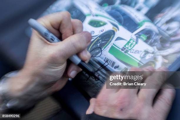 Ben Keating signs an autograph card before qualifying for the Motul Petit Le Mans at Road Atlanta on October 6, 2017 in Braselton, Georgia.