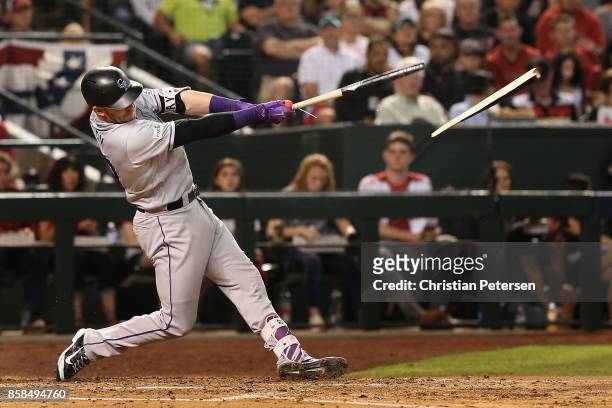 Trevor Story of the Colorado Rockies hits a broken bat single during the fourth inning of the National League Wild Card game against the Arizona...