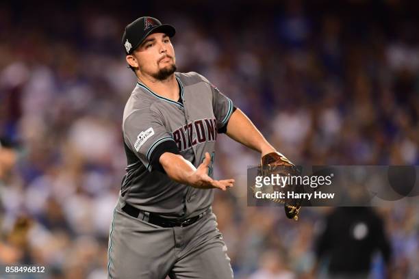 Zack Godley of the Arizona Diamondbacks throws the ball to first base on a bunt attempt by Clayton Kershaw of the Los Angeles Dodgers in the fourth...
