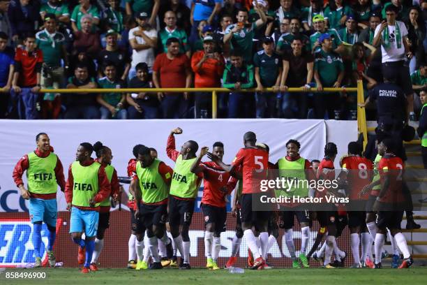 Shahdon Winchester of Trinidad & Tobago celebrates with teammates after scoring the first goal of his team during the match between Mexico and...