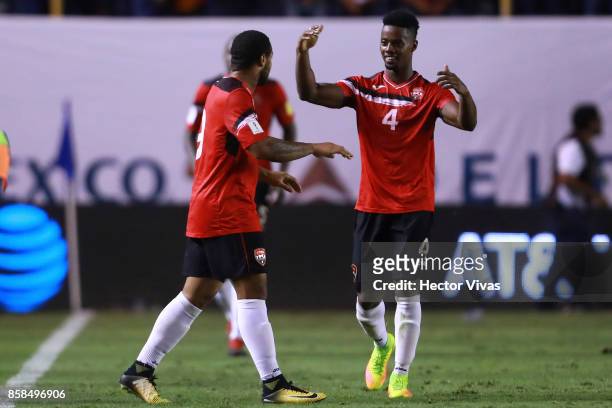 Shahdon Winchester of Trinidad & Tobago celebrates with teammates after scoring the first goal of his team during the match between Mexico and...