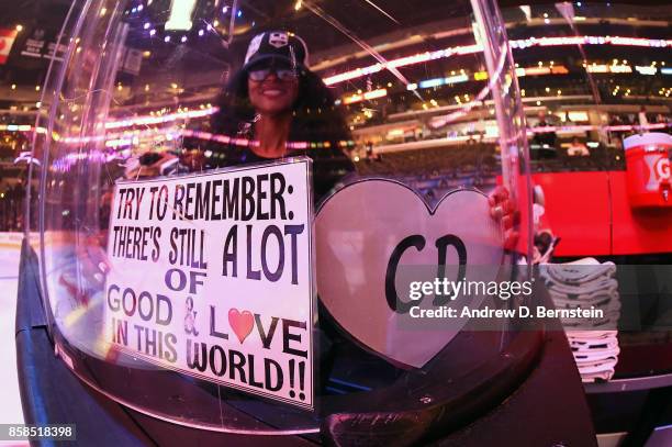 Los Angeles Kings fan holds up signs in honor of Kings employee Christiana Duarte, a victim of the recent mass shooting in Las Vegas before a game...
