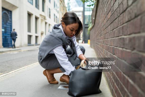 businesswoman checking her purse in a hurry - black handbag stock pictures, royalty-free photos & images