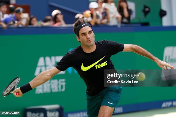 Roger Federer of Switzerland practises with Wu Di of China in the 2017 Shanghai Rolex Masters at Qizhong Stadium on October 7, 2017 in Shanghai,...