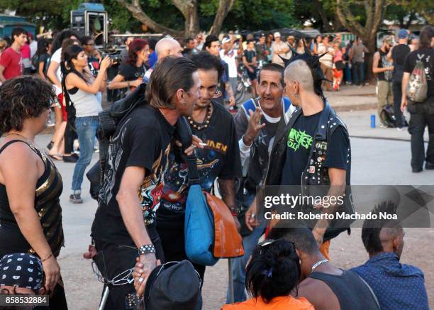 Ciudad Metal' or City of Metal' rock festival. Four rock musicians talking excitedly amid a crowd of people. Rock is not common in the island so the...