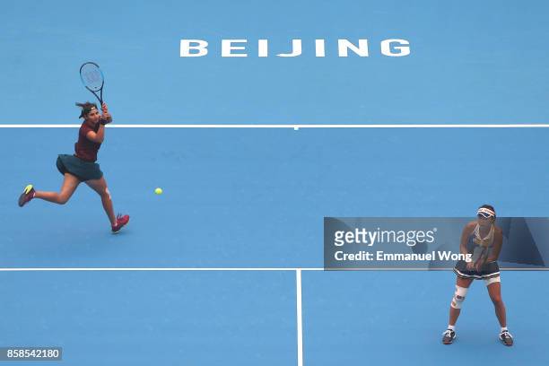 Sania Mirza of India and Shuai Peng of China return a shot during their Women's double semi finals match against Yung-Jan Chan of Chinese Taipei and...