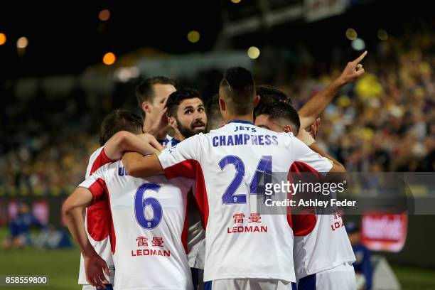Jets players celebrate a goal from Joseph Champness of the Jets during the round one A-League match between the Central Coast Mariners and the...