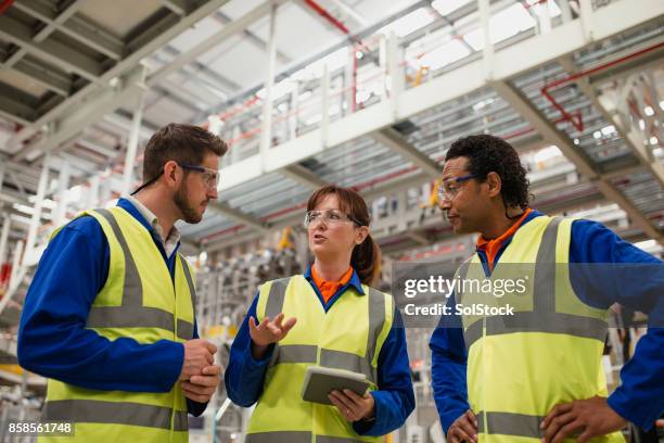 factory workers having a discussion - igualidade de géneros imagens e fotografias de stock