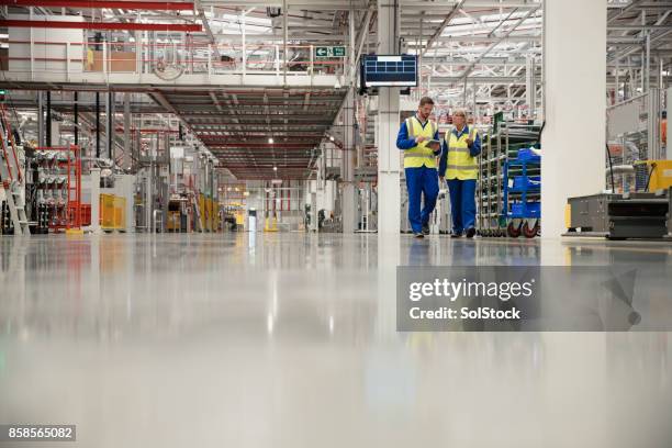 arbeiter zu fuß durch eine fabrik - industry worker production line stock-fotos und bilder