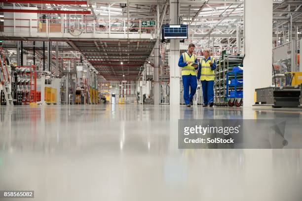 workers walking through a factory - factory stock pictures, royalty-free photos & images