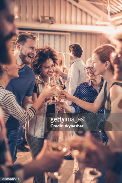 groep van vrolijke mensen roosteren met wijn op een feestje. - office party stockfoto's en -beelden