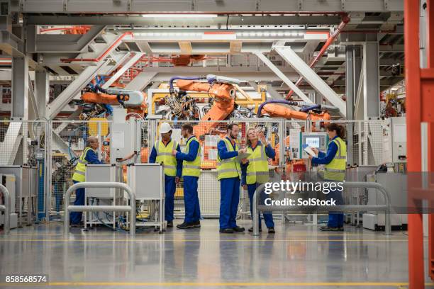 group of factory workers - robotic arm factory stock pictures, royalty-free photos & images