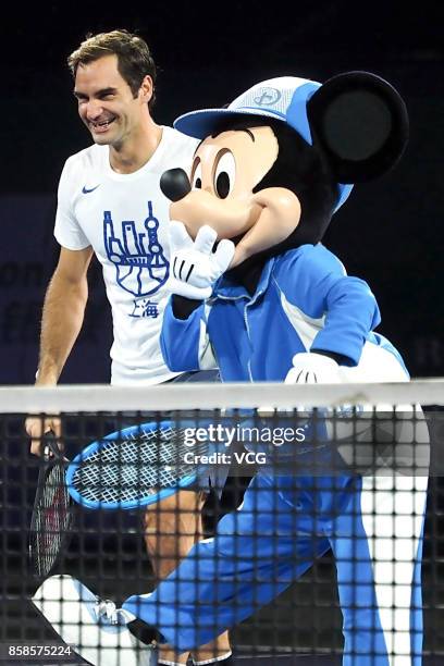 Roger Federer of Switzerland attends a friendly tennis match with Disney characters Mickey Mouse and Goofy ahead of the 2017 Shanghai Rolex Masters...