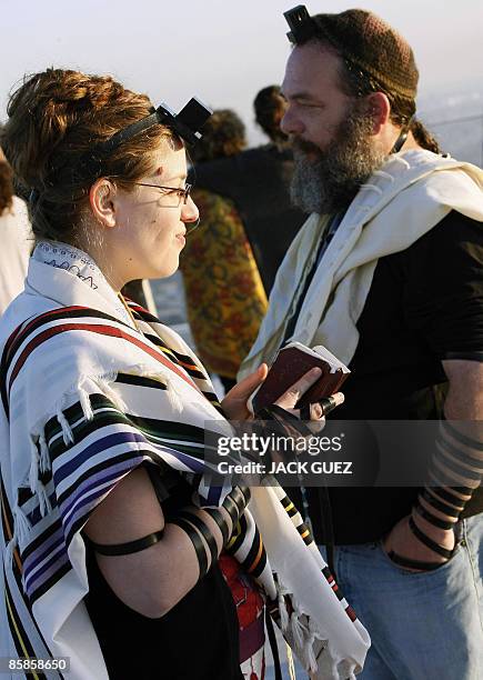 Reform Jewish woman wearing phylacteries and prayer shawl , customarily wore only by men, prays on the roof of Tel Aviv�s Azrieli Towers during...