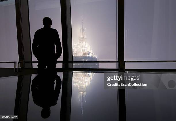 window with man looking at the skyline of shanghai - conference table stock pictures, royalty-free photos & images