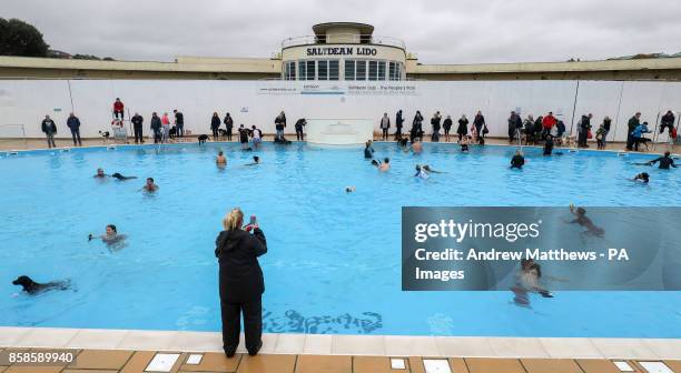 Dogs and their owners swimming at Saltdean Lido in the Oval Park, Saltdean, as the lido has invited dogs to enjoy the facility before it closes for...