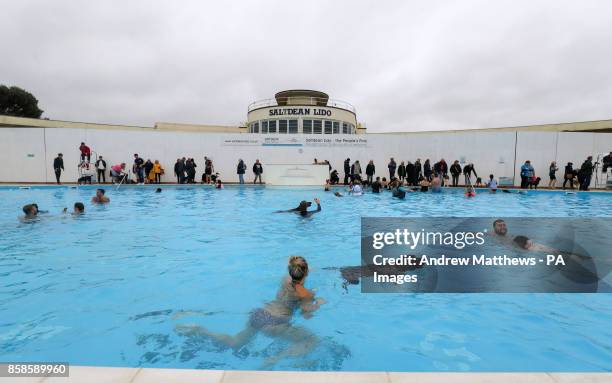 Dogs and their owners swimming at Saltdean Lido in the Oval Park, Saltdean, as the lido has invited dogs to enjoy the facility before it closes for...