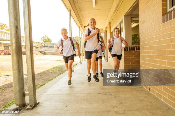 excited girl junior high school students running at school - last day of school stock pictures, royalty-free photos & images