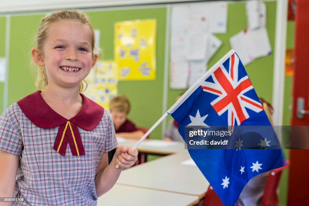 Bandeira australiana acenando por aluno de escola primária para o dia da Austrália
