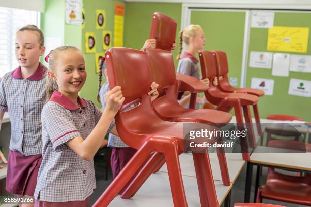 primary school students putting up chairs at the end of class - last day of school stock pictures, royalty-free photos & images