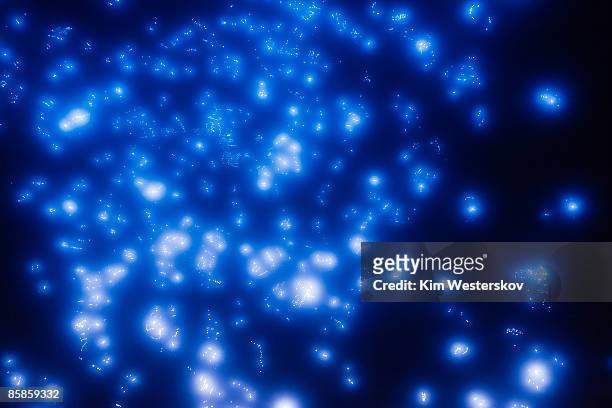 many glowing points of blue light in dark space - westerskov stock pictures, royalty-free photos & images