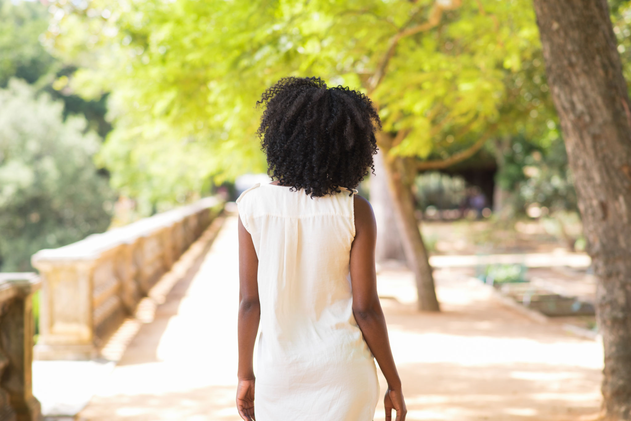 Rear view of young woman walking in park Rear view of young woman walking in park