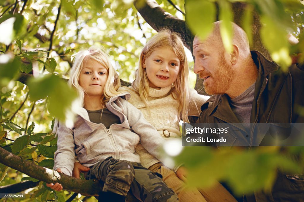 Vader en twee mooie jonge blonde zusters in herfst Park