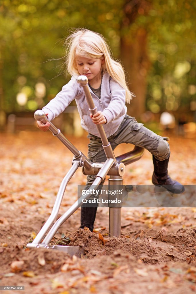 Schöne junge blonde Mädchen spielen in Autumnal Park