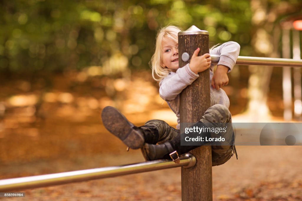 Beautiful young blond girl playing in Autumnal Park