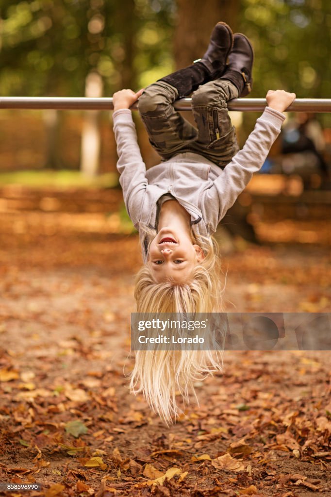 Schöne junge blonde Mädchen spielen in Autumnal Park