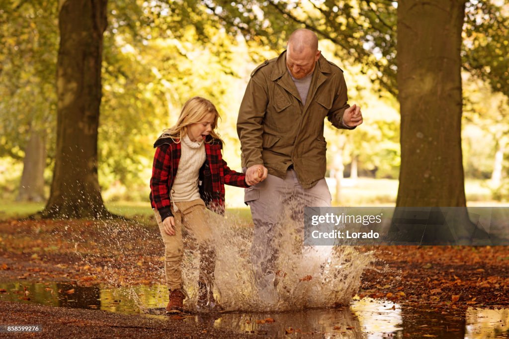 Pai e bela jovem filha loira no parque outono