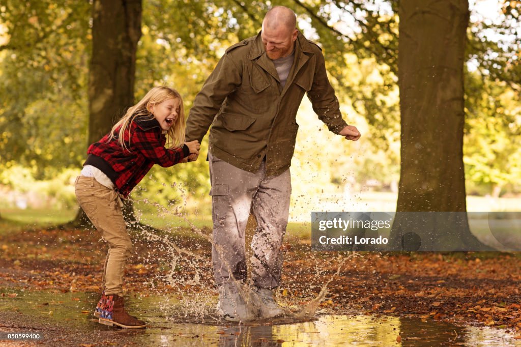 Father and Beautiful young blond daughter in Autumnal Park