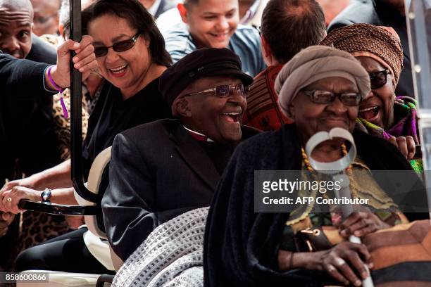 South African Nobel Peace Prize laureate Archbishop Desmond Tutu reacts as he arrives to attend the unveiling ceremony of the "Arch for the Arch" as...
