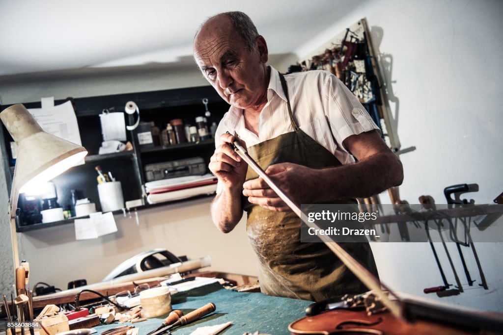 Senior man muziek instrument Ahmar en herstellen van de boog