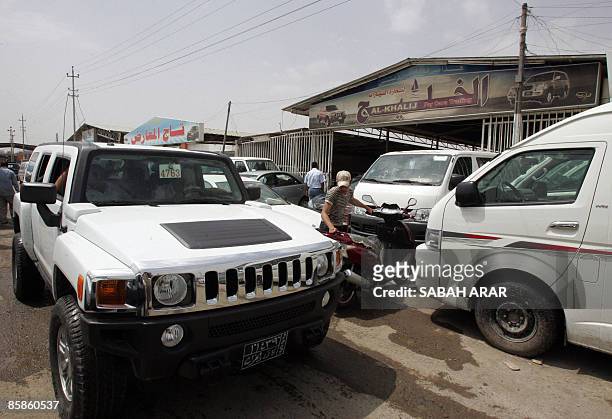 An Iraqi drives a Hummer at a car dealership in Baghdad on April 8, 2009. Iraqis display an unexpected demand on the US-made Hummer, which is a...