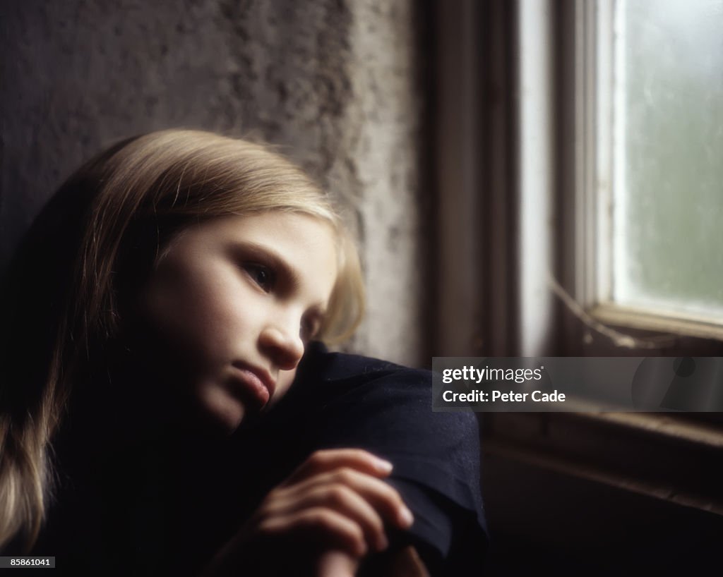 Young girl looking out of window