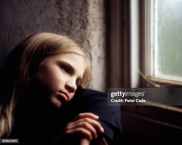 young girl looking out of window - britain in the 90s stockfoto's en -beelden