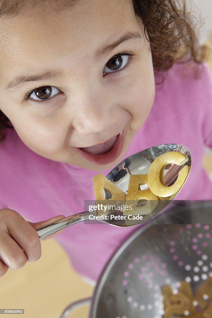 Girl eating alphabet pasta