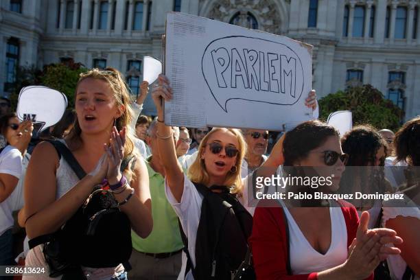 Woman shouts slogans and holds a placard reading 'Parlem' amid other demonstrators protesting in front of Madrid City Hall under the slogan...