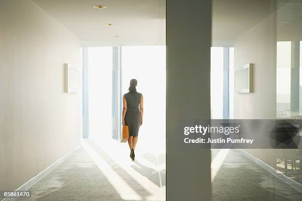 businesswoman in corridor, rear view - farewell fotografías e imágenes de stock