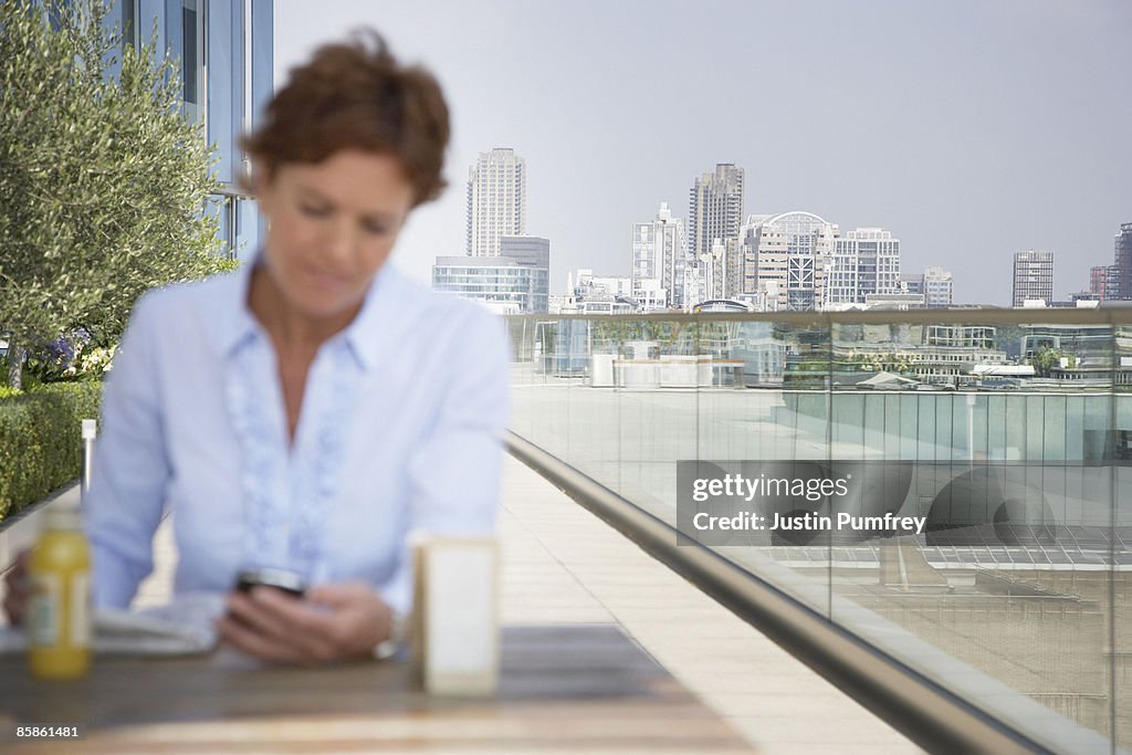 Businesswoman using mobile phone, defocussed 