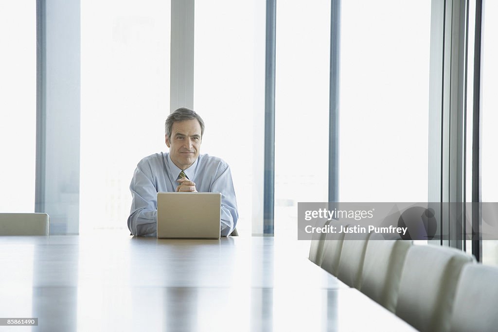 Businessman working on laptop in conference room