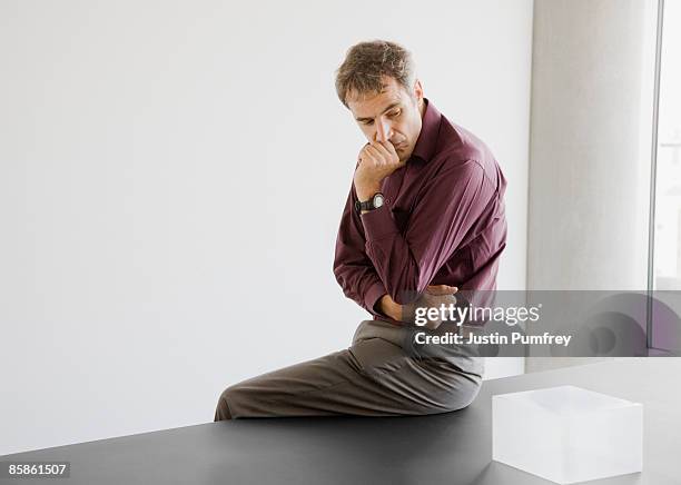 businessman sitting on desk - thinking outside the box englische redewendung stock-fotos und bilder