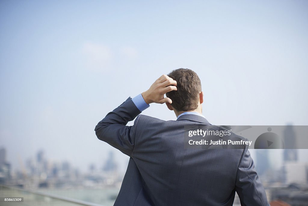 Businessman on rooftop, close up, rear view