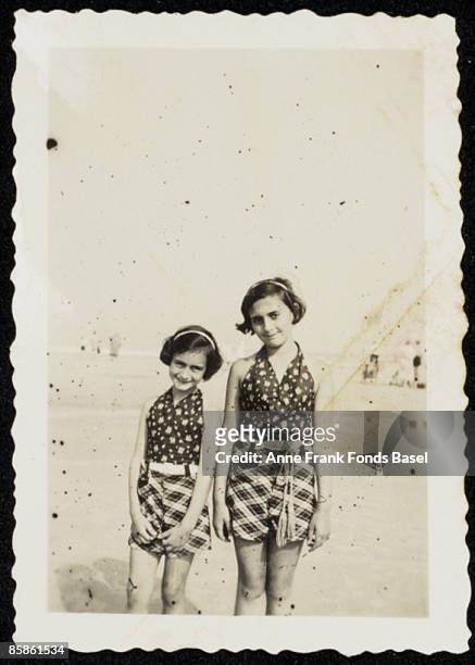 Anne Frank and her sister Margot standing on a beach, circa 1935.