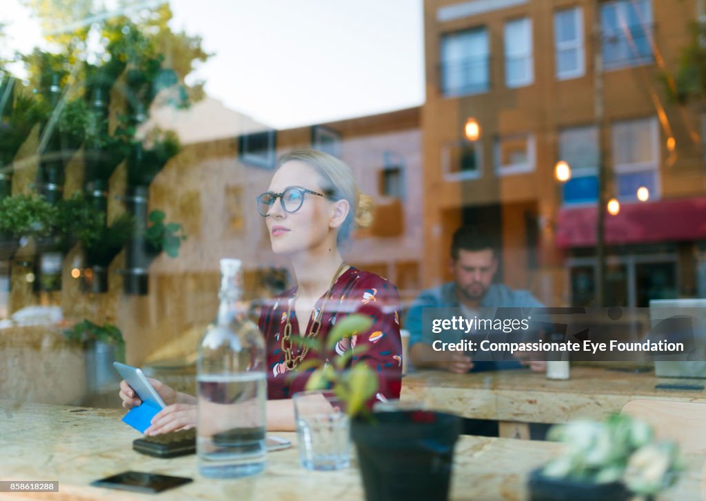 Businesswoman using digital tablet in cafe