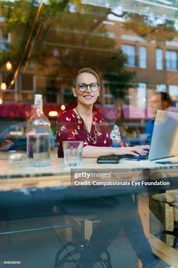 Businesswoman using laptop in cafe