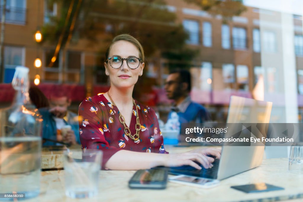 Businesswoman using laptop in cafe