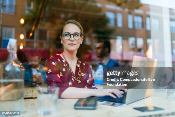 businesswoman using laptop in cafe - transparent blouse stock pictures, royalty-free photos & images